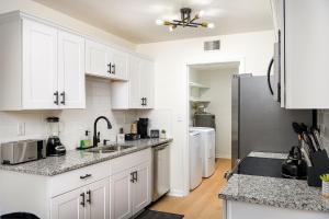 a kitchen with white cabinets and a refrigerator at Emerald Retreat - Central & Stylish - 2 BR/2 BA in Winston-Salem