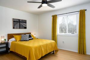 a bedroom with a bed with yellow curtains and a window at Emerald Retreat - Central & Stylish - 2 BR/2 BA in Winston-Salem