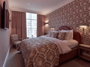 a bedroom with a large bed and a window at Good Seasons Hotel Den Bosch in Den Bosch