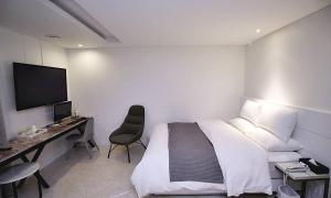 a bedroom with a bed and a desk with a computer at Hapjeong Circle Hotel in Seoul