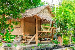 ein Bambushaus mit einem Strohdach in der Unterkunft Camp Chamao in Ban Noen Sombun