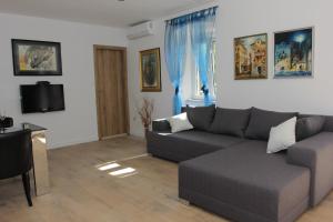 a living room with a couch and a tv at Apartment House Vitaic in Supetar