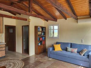 sala de estar con sofá azul y estante para libros en Mani Hill House en Gytheio