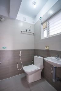 a bathroom with a toilet and a sink at Aafiya lakeview Apartments in Coimbatore