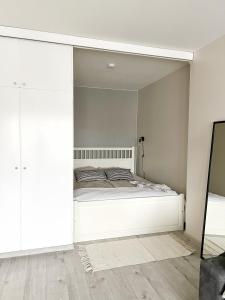 a bedroom with a white bed and a mirror at Bright & Cozy, Renovated Studio in the Lahti Center in Lahti