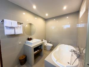 a white bathroom with a sink and a toilet at The Payogan Villa Resort and Spa in Ubud