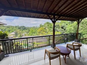 uma varanda com uma mesa e cadeiras e uma vista em The Payogan Villa Resort and Spa em Ubud