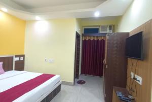 um quarto de hotel com uma cama e uma televisão em Hotel Sashi Puri Near Sea Beach & Temple - Best Choice of Travellers em Puri