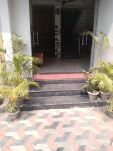um alpendre com vasos de plantas em frente a uma porta em Hotel Sashi Puri Near Sea Beach & Temple - Best Choice of Travellers em Puri