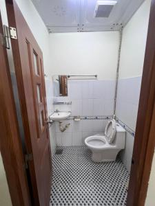 małą łazienkę z toaletą i umywalką w obiekcie Nhà Nghỉ Happy (Nguyên Thảo 2) w Ho Chi Minh