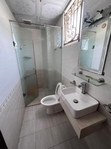 ein Bad mit einem WC, einem Waschbecken und einer Dusche in der Unterkunft Nhà Nghỉ Happy (Nguyên Thảo 2) in Ho-Chi-Minh-Stadt