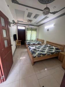 1 dormitorio con 2 camas y TV. en Nhà Nghỉ Happy (Nguyên Thảo 2), en Ho Chi Minh