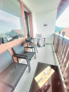 a balcony with two chairs and a table at Alp-Juwel mit Pool und Sauna für Familien und Hunde ideal in Missen-Wilhams