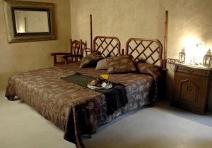a bedroom with a large bed with a dresser and a table at La Premsa Hotel Rural in Cardona