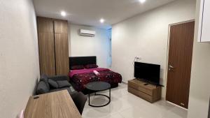 una pequeña sala de estar con cama y sofá en Chor’s Homestay, en Kuching