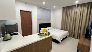Habitación con cama y cocina con fregadero en Chor’s Homestay en Kuching