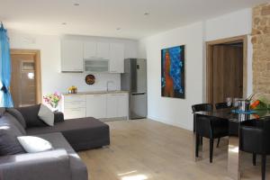 a living room with a couch and a table and a kitchen at Apartment House Vitaic in Supetar