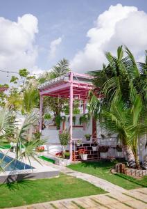 ein Haus mit einem Pool und Palmen in der Unterkunft Nguyễn Lagi Homestay in La Gi