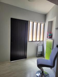 Zimmer mit einer schwarzen Tür und einem Stuhl in der Unterkunft MI CASITA de Lanzarote in Arrecife