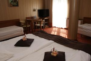 um quarto de hotel com duas camas e uma mesa em Grot Hotel em Malbork