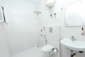 uma casa de banho branca com um WC e um lavatório em Hotel Mars Meg at Delhi Airport em Nova Deli