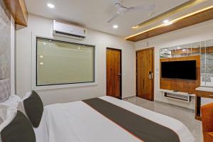 1 dormitorio con cama y ventana grande en Super Collection O Hotel Alpha One, en Ahmedabad