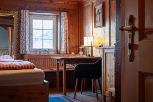 a bedroom with a desk and a bed and a window at FP Muehlmann&Schoen in Innervillgraten