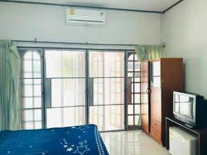 um quarto com uma cama, uma televisão e uma janela em OYO 75484 My Home Guesthouse em Ban Bang Saen (1)