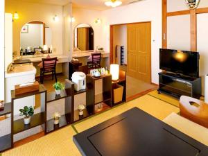 uma grande sala de estar com televisão e uma sala de estar em Hotel Symphony Sagae Onsen em Sagae