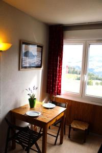 mesa de comedor con 2 sillas y 2 ventanas en Résidence Le Bois D'aurouze - Studio pour 3 Personnes 244 en Saint-Étienne-en-Dévoluy