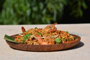 a bowl of noodles with shrimp and vegetables on a table at Surfescape Fuerteventura in Lajares