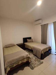 um quarto com duas camas e uma janela em Dpto. coto privado con alberca em Mazatlán