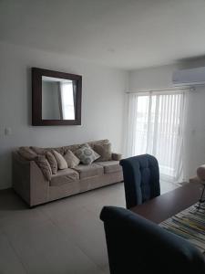 a living room with a couch and a mirror at Dpto. coto privado con alberca in Mazatlán