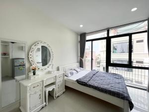 a white bedroom with a sink and a mirror at Dlux Bùi Văn Thêm in Ho Chi Minh City
