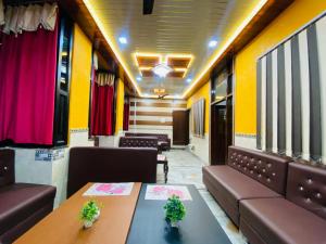 a room with couches and tables in a train at Friends Guest House & Hostel- near TAJ MAHAL in Agra