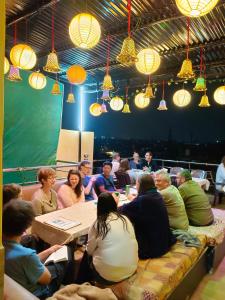un grupo de personas sentadas alrededor de una mesa en una habitación en Friends Guest House & Hostel- near TAJ MAHAL en Agra