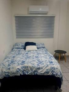a bed with a blue and white comforter in a bedroom at hogar, dulce hogar 1 in Torreón