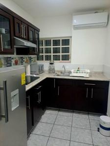 a kitchen with a sink and a refrigerator at hogar, dulce hogar 1 in Torreón