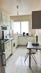 eine Küche mit einer Spüle und einer Waschmaschine in der Unterkunft Résidence de montagne française in Aulnay-sous-Bois