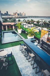 a rooftop patio with a pool and tables and chairs at Hotel Casa Panama in Panama City