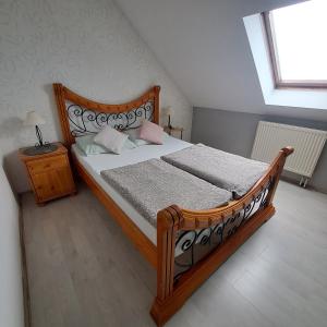 a bedroom with a large wooden bed and a window at Noclegi Srebrna Góra in Srebrna Góra