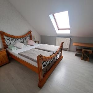 a bedroom with a large wooden bed with a skylight at Noclegi Srebrna Góra in Srebrna Góra