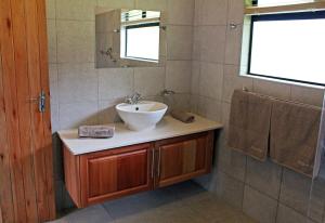 a bathroom with a sink and a mirror at Sungubala Eco Camp in Bergville