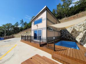a house with a swimming pool next to a building at 여수 thestay in Yeosu