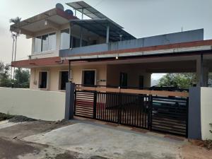 a house with a gate in front of it at Mistvalley Hut in Chithragiri