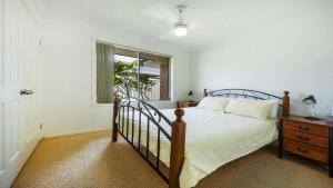 1 dormitorio con cama y ventana en Taine Court en Yamba