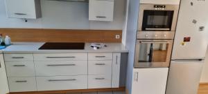 a kitchen with white cabinets and a refrigerator at Haus Blindenmarkt in Amstetten
