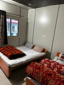 2 aparte bedden in een kamer met een raam bij Brahma Kamal in Phata