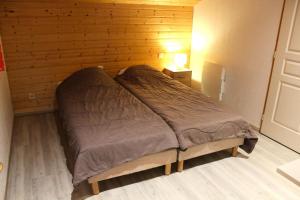 a bed in a room with a wooden wall at Les Chalets Margot - Chalets pour 6 Personnes 651 in Le Dévoluy