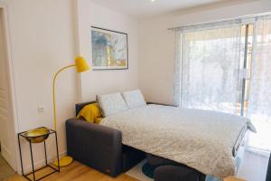 sypialnia z łóżkiem, lampą i oknem w obiekcie Appartement avec jardin w mieście Bègles